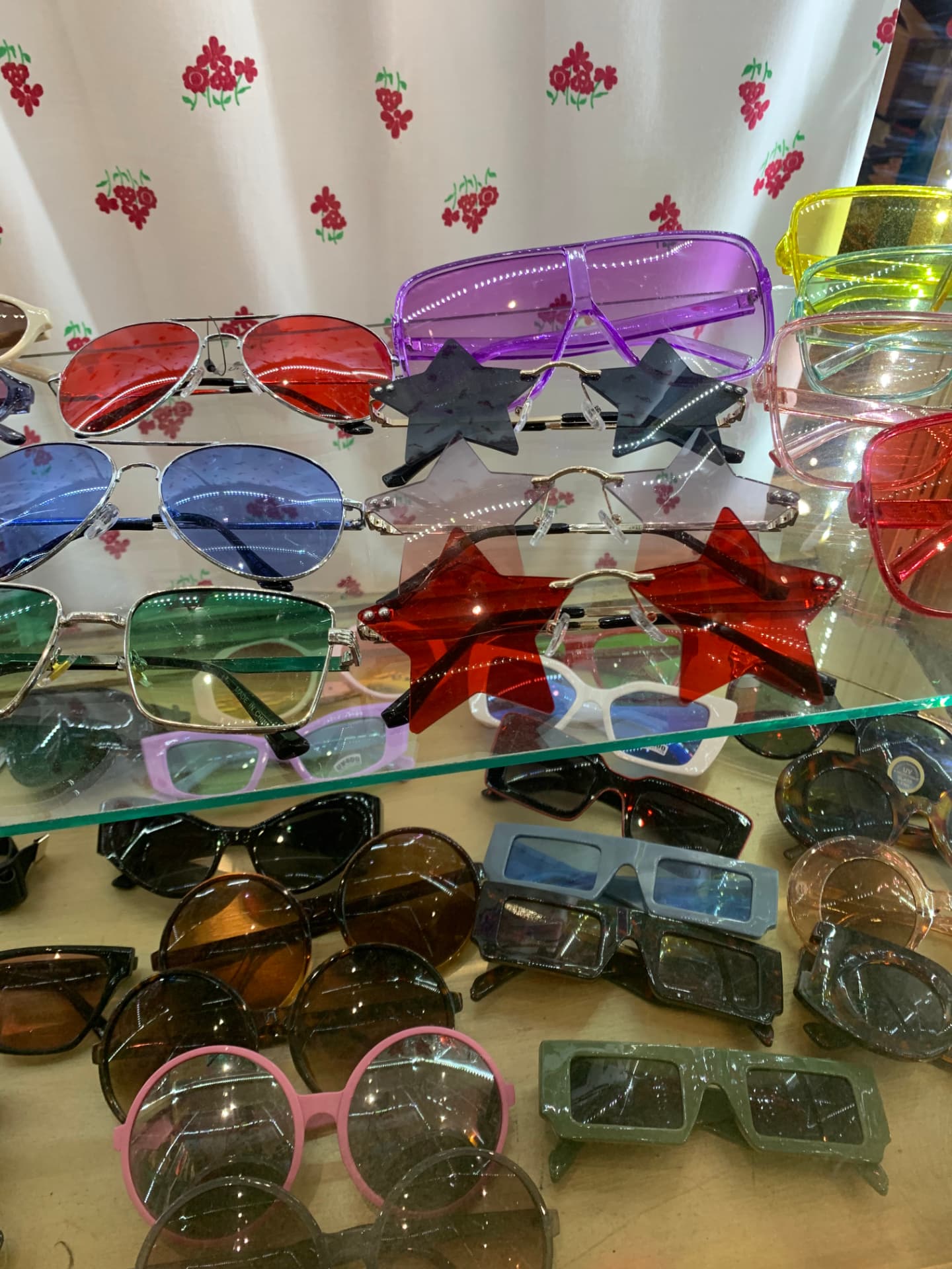 Shelves of colorful sunglasses including star-shaped frames