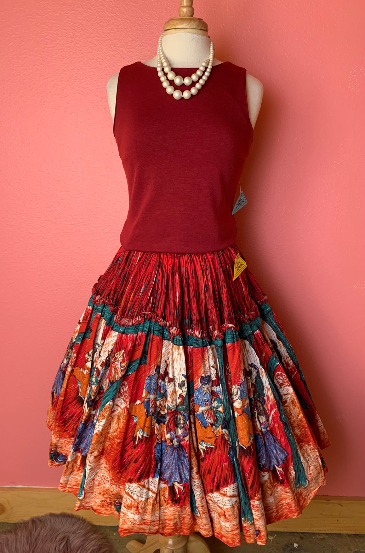 Red top with pearls and a printed square-dance circle skirt
