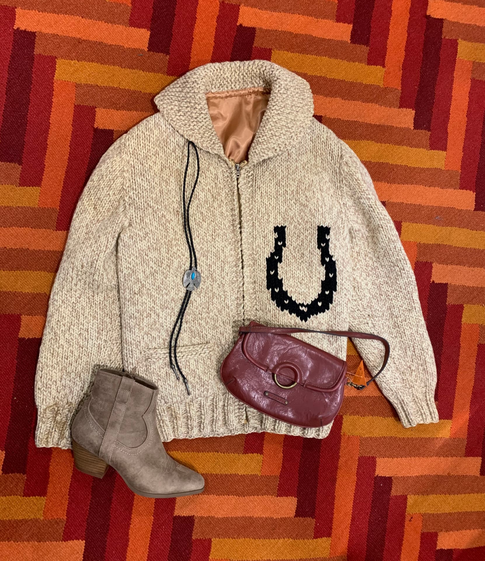 Knit horseshoe cardigan with bolo tie, suede boot, and leather purse