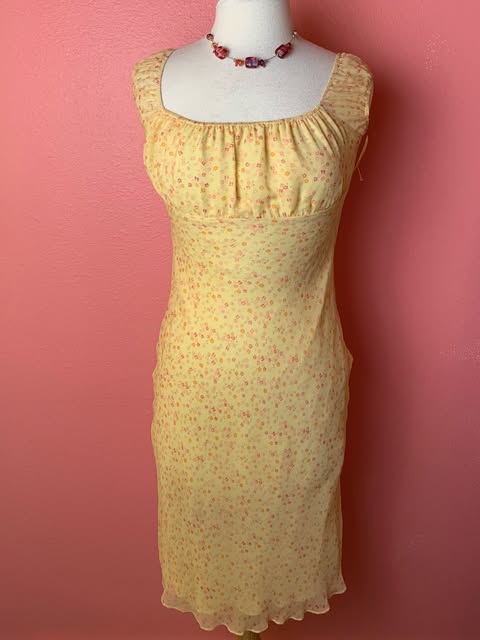 Yellow floral dress on a pink wall